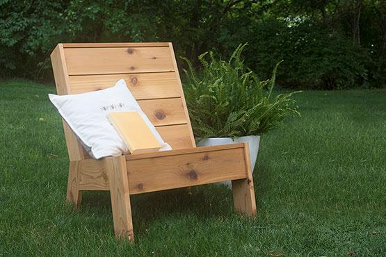 Outdoor lounge chair with decorative pillow in backyard