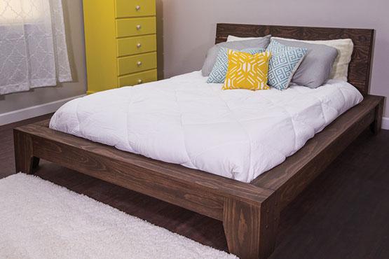platform bed with bedding and colorful chest of drawers