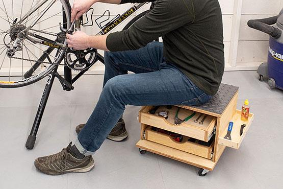working on a bike while sitting on a rolling work seat